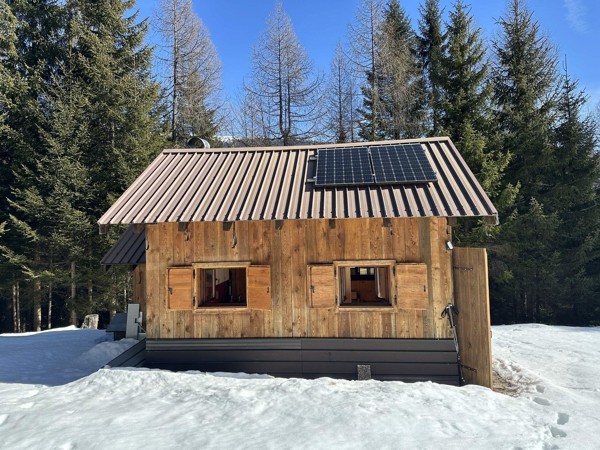 Berghütte im Schnee am Waldrand